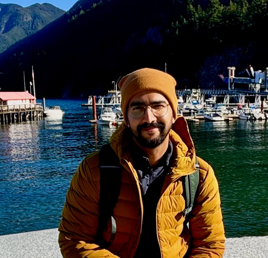 Amit, the founder of US Grants Database, standing in front of a harbour in Vancouver
